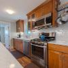 Kitchen showing gas range, dishwasher, microwave, pot rack