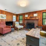Spacious living room with wood burning fireplace and television.