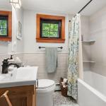 Bathroom has a vanity, tub/shower, toilet and a heated floor.