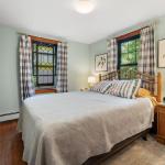 Primary bedroom with queen size bed, two night stands, dresser, and closet.