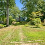 Large sloped front lawn with ample parking at curb.